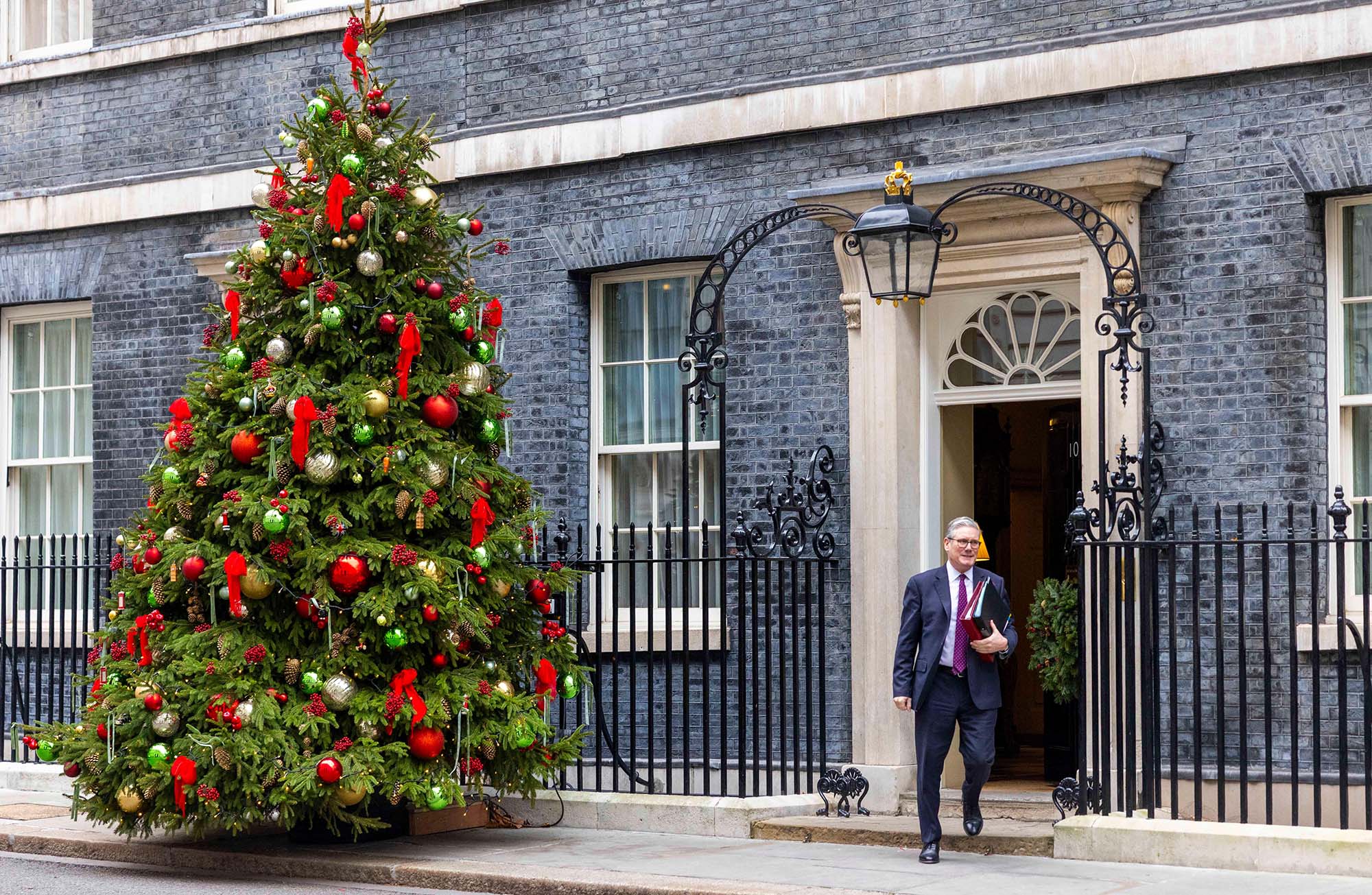 Keir Starmer leaves Number 10 in front of the Downing Street Christmas tree